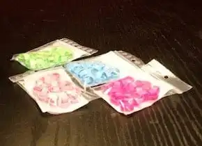 Packets of plastic bird leg rings numbered 1 to 25 in assorted colours: pink, blue, green and red